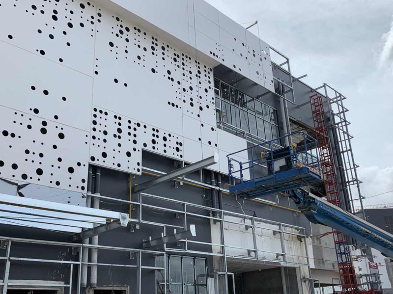 Installation of white aluminum wall panels Instalación de paneles de pared de aluminio blanco.